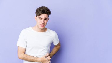 Mor arka planda karaciğer ağrısı çeken, karnı ağrıyan genç beyaz bir adam..