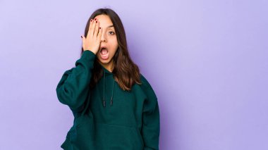 Genç, melez İspanyol bir kadın izole edilmiş, yüzünün yarısını avuç içiyle kaplayarak eğleniyor..