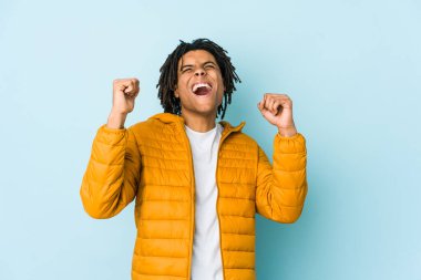 Genç melez adam zaferden sonra yumruğunu kaldırıyor, kazanan konsept.