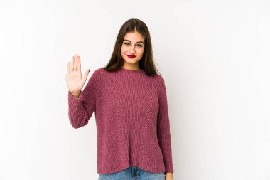 Beyaz arka planda izole edilmiş genç beyaz kadın gülümseyerek beş numarayı parmaklarıyla gösteriyor..