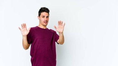 Beyaz arka planda izole genç beyaz adam yakın bir tehlike nedeniyle şoka uğruyor