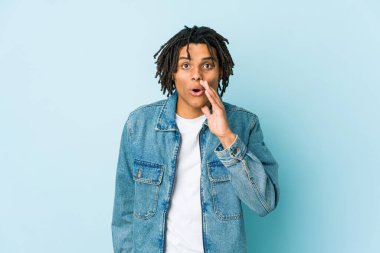 Kot ceket giyen genç siyahi adam gizli bir fren haberi veriyor ve yan bakıyor.