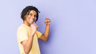 Genç Afro-Amerikan Rasta adamı gamsız ve heyecanlı bir şekilde tezahürat yapıyor. Zafer konsepti.