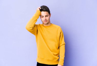 Mor arka planda izole edilmiş genç beyaz adam yorgun ve uykulu ellerini başının üstünde tutuyor..