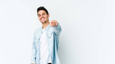 Beyaz arka planda soyutlanmış beyaz tenli genç adam öne bakan neşeli gülümsemeler..