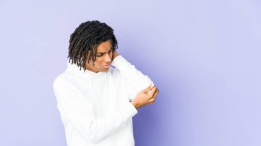 Genç Afrikalı Amerikalı Rasta adam dirsek masajı yapıyor, kötü bir hareketin ardından acı çekiyor..