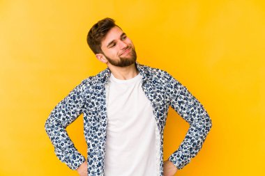 Sarı arka planda izole edilmiş genç beyaz adam hedeflere ve amaçlara ulaşma hayali kuruyor.