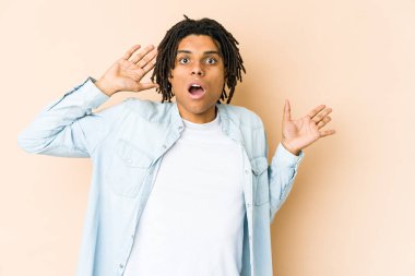 Genç Afro-Amerikan Rasta-Man 'in elinde avuç içi fotokopi alanı var, el üstünde tutuyor. Şaşırmış ve mutlu..