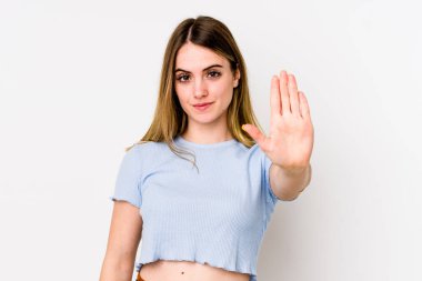 Beyaz arka planda izole edilmiş genç beyaz bir kadın elini uzatmış, dur işareti göstererek seni engelliyor..