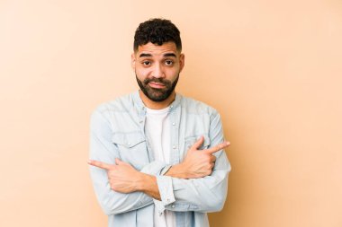 Genç melez Arap adam iki seçenek arasında seçim yapmaya çalışıyor..