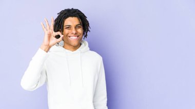 Genç Afro-Amerikan Rasta 'lı neşeli ve kendinden emin adam iyi bir jest yapıyor..