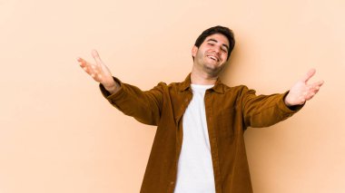 Bej arka planda izole edilmiş genç adam kameraya sarıldığı için kendinden emin hissediyor..