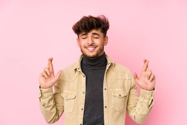 Arka planda poz veren genç bir Arap, şans dilemek için şans diliyor.