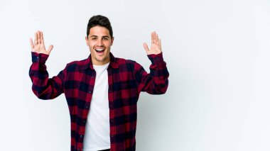 Beyaz arka planda izole genç beyaz adam hoş bir sürpriz alıyor, heyecanlı ve el kaldırıyor..