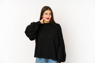 Beyaz arka planda soyutlanmış beyaz tenli bir kadın kafasının arkasına dokunuyor, düşünüyor ve bir seçim yapıyor..