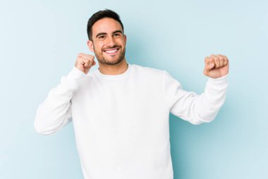 Genç beyaz adam mavi arka planda izole edilmiş dans ediyor ve eğleniyor..