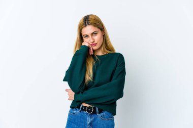 Beyaz arka planda izole edilmiş genç sarışın kadın üzgün ve dalgın hissediyor, kopyalama alanına bakıyor..