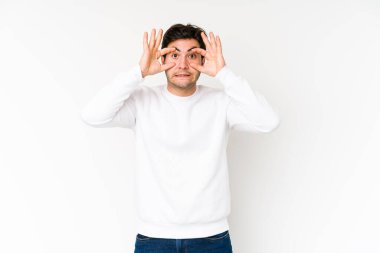 Beyaz arka planda izole edilmiş genç bir adam bir başarı fırsatı bulmak için gözlerini açık tutuyor..