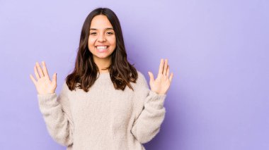 Latin kökenli genç bir kadın 10 numarayı elleriyle gösteriyor..