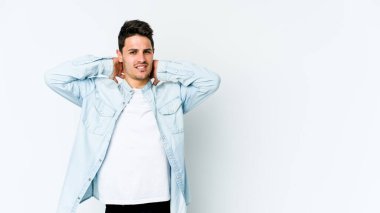 Beyaz arka planda izole edilmiş genç beyaz bir adam kafasının arkasına dokunuyor, düşünüyor ve bir seçim yapıyor..