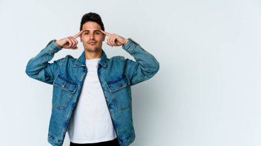 Beyaz arka planda izole edilmiş genç beyaz bir adam bir göreve odaklanmış, işaret parmaklarını işaret ediyor..