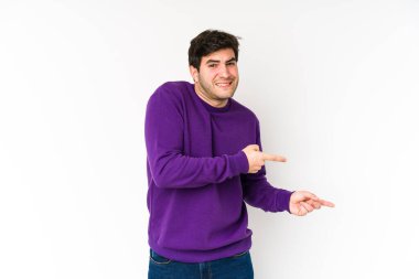 Beyaz arka planda izole edilmiş genç adam işaret parmağıyla bir kopyalama alanını işaret ederek şok oldu..