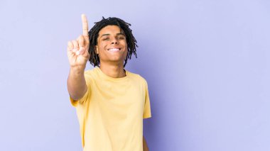 Genç Afro-Amerikan Rasta adamı bir numarayı parmağıyla gösteriyor..