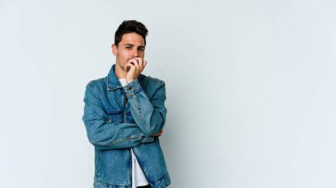 Beyaz arka planda izole edilmiş genç beyaz bir adam şüpheli, belirsiz, seni muayene ediyor..