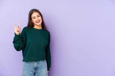 Mor arka planda izole edilmiş genç beyaz kadın boynuzlarını devrim konsepti olarak gösteriyor..