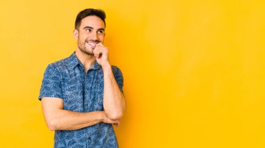 Kafkasyalı genç adam sarı fırında izole edilmiş. Rahatlamış bir şekilde bir şeyin fotokopi odasına baktığını düşünüyor..