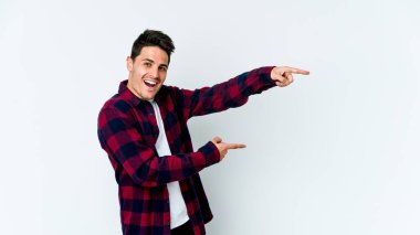 Beyaz arka planda izole edilmiş genç beyaz bir adam işaret parmağıyla işaret ettiği için heyecanlı..