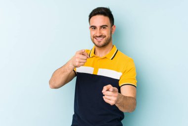 Mavi arka planda izole edilmiş genç beyaz adam öne bakan neşeli gülümsemeler.