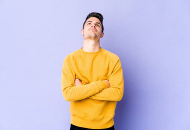 Mor arka planda izole edilmiş genç beyaz adam tekrarlanan bir görevden bıktı..