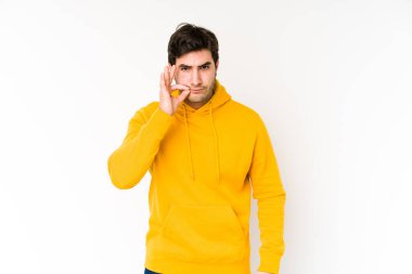 Genç adam beyaz arka planda izole edilmiş, parmakları dudaklarında bir sır saklıyor..