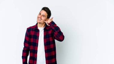 Beyaz arka planda izole edilmiş genç beyaz bir adam parmakları olan bir cep telefonu hareketi gösteriyor..