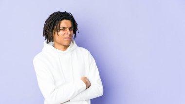 Genç Afro-Amerikan Rasta 'lı mutsuz adam iğneleyici ifadesiyle kameraya bakıyor..