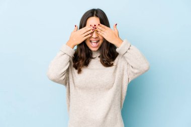 Genç, melez İspanyol bir kadın izole edilmiş, elleriyle gözlerini kapatmış, gülümseyerek bir sürpriz bekliyor..