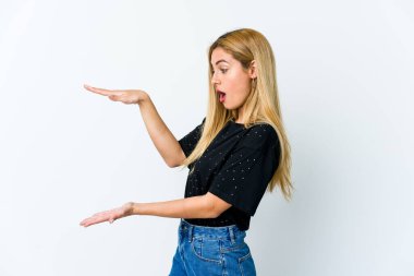 Beyaz arka planda izole edilmiş genç sarışın kadın elleri arasında bir kopya alanı tutarken şok olmuş ve hayrete düşmüştü..