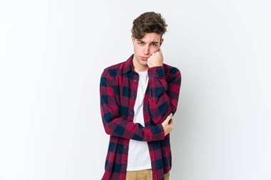 Beyaz arka planda izole edilmiş, üzgün ve dalgın hisseden genç beyaz bir adam fotokopi alanına bakıyor..