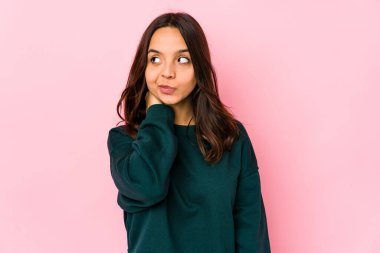 Genç, melez, İspanyol bir kadın. Kafasının arkasına dokunuyor, düşünüyor ve bir seçim yapıyor..