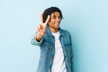 Genç siyah adam kot ceket giyiyor. İki numarayı parmaklarıyla gösteriyor..