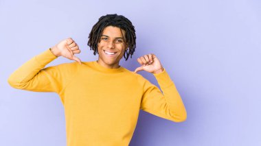 Rasta saç stili giyen genç siyah adam gururlu ve kendinden emin hissediyor, örnek olarak.