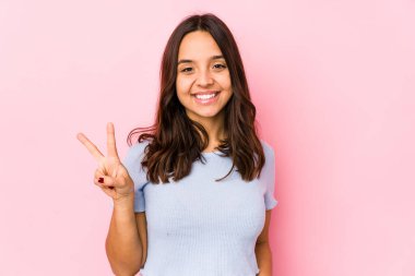 Genç, melez, Latin bir kadın iki numarayı parmaklarıyla gösteriyor..