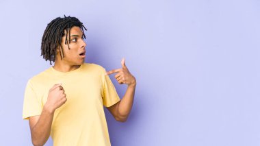 Genç Afro-Amerikan Rasta adamı parmağını gösterip, gülümseyerek şaşırdı..