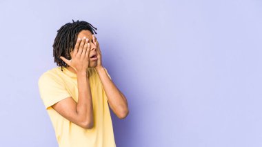 Genç Afrikalı Amerikalı Rasta adam elleriyle gözlerini kapatmaktan korkuyor..