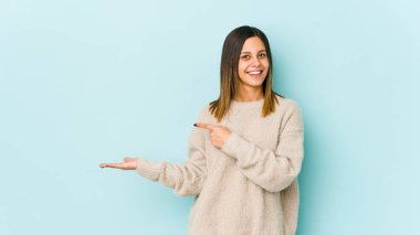 Mavi arka planda izole edilmiş genç bir kadın..