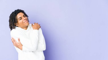 Genç Afro-Amerikan Rasta adamı sarılıyor, kaygısız ve mutlu gülümsüyor..