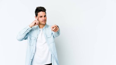 Beyaz arka planda izole edilmiş genç beyaz bir adam şakağı parmağıyla işaret ediyor, düşünüyor ve bir göreve odaklanıyor..