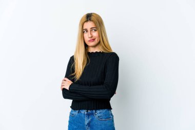 Beyaz arka planda izole edilmiş genç sarışın kadın alaycı bir ifadeyle kameraya bakıyor..