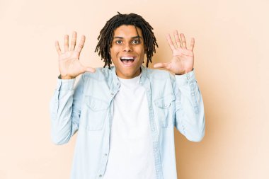 Genç Afrikalı Amerikalı Rasta adam hoş bir sürpriz alıyor, heyecanlı ve el kaldırıyor..